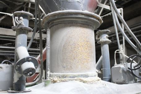 主原料のトウモロコシを家畜の日齢などに合わせた粗さに粉砕し、副原料（大豆粕、きな粉、マイロなど）を合わせて撹拌。